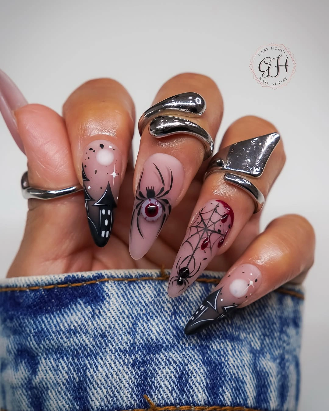 Long stiletto nude nails with a metallic-looking spider focal accent