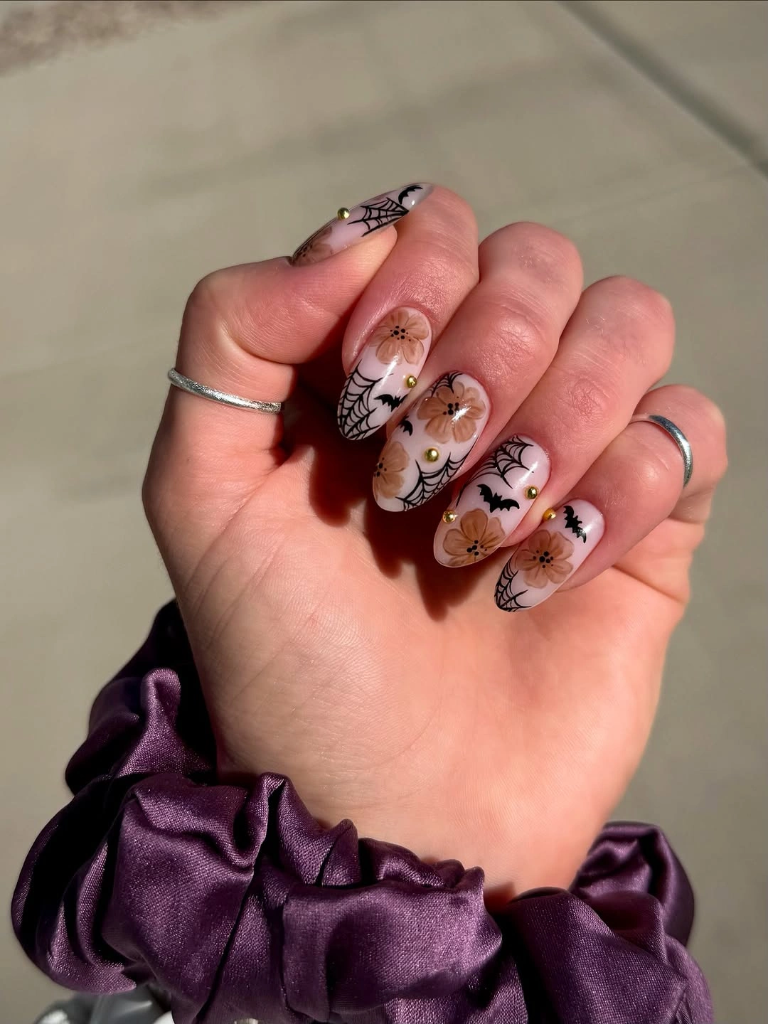 Medium almond brown and nude nails with small Halloween illustrations