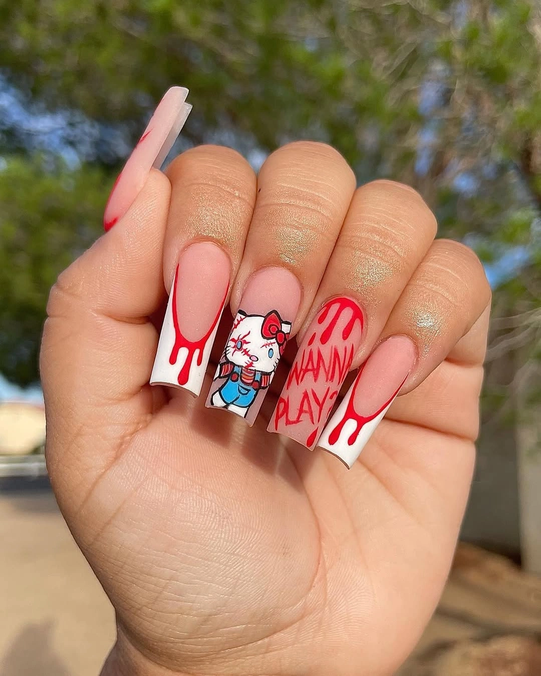 Long square white and nude nails with bold red drip graphics