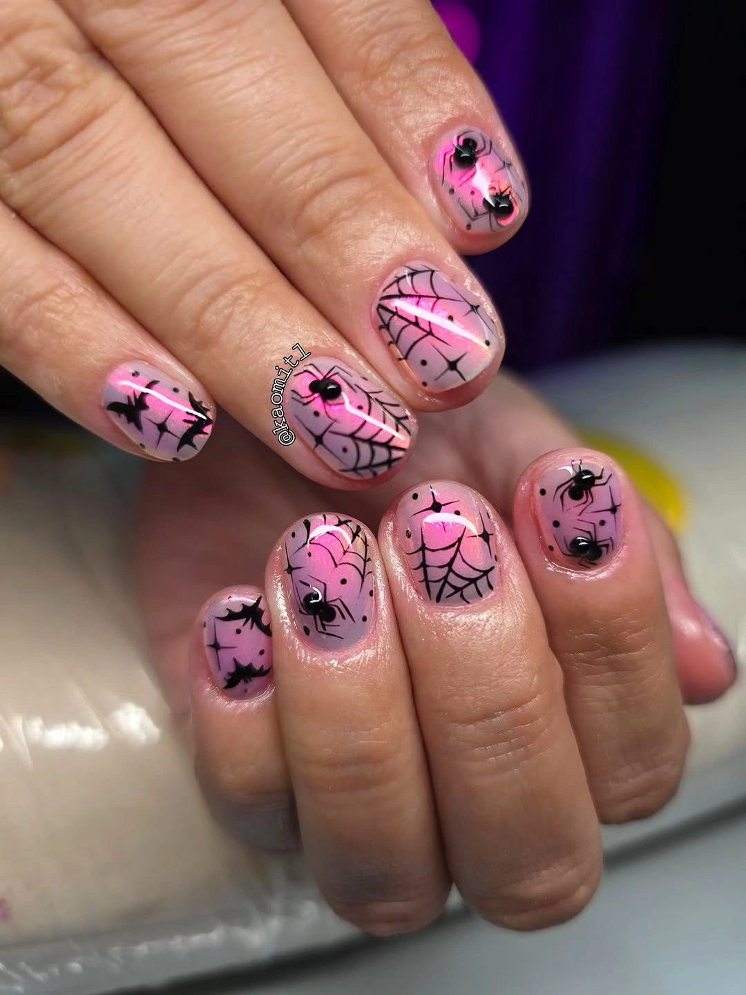 Short pink nails with black web-like lines and tiny spooky details