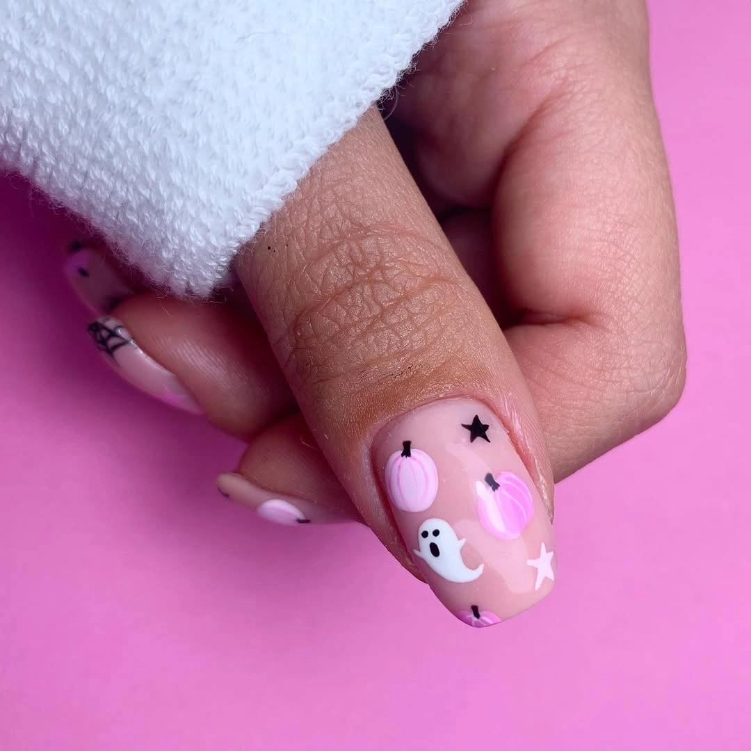 Short rounded pink nails with tiny ghost doodles and seasonal marks