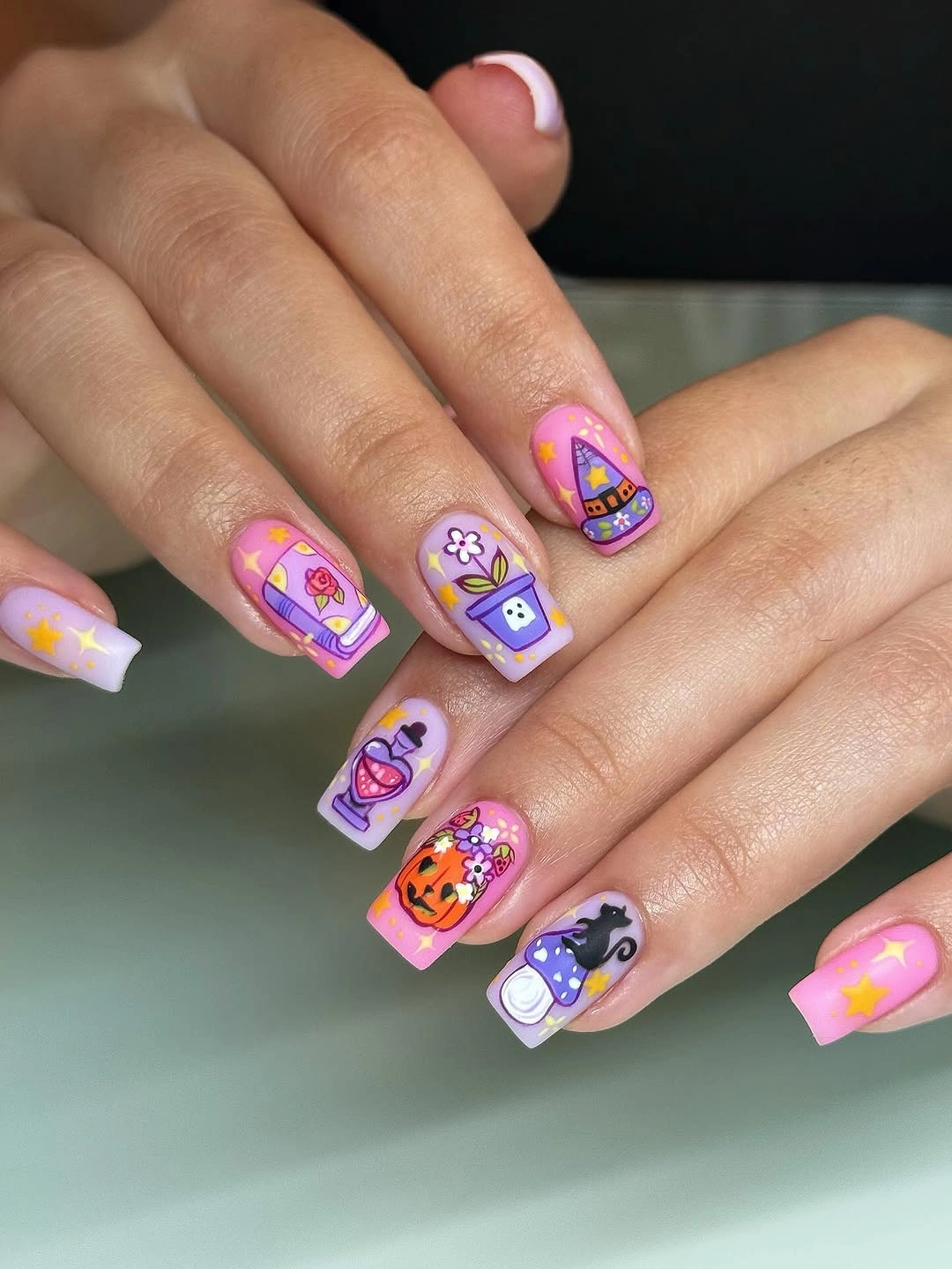 Short square neon nails with colorful ghosts pumpkins and Halloween icons