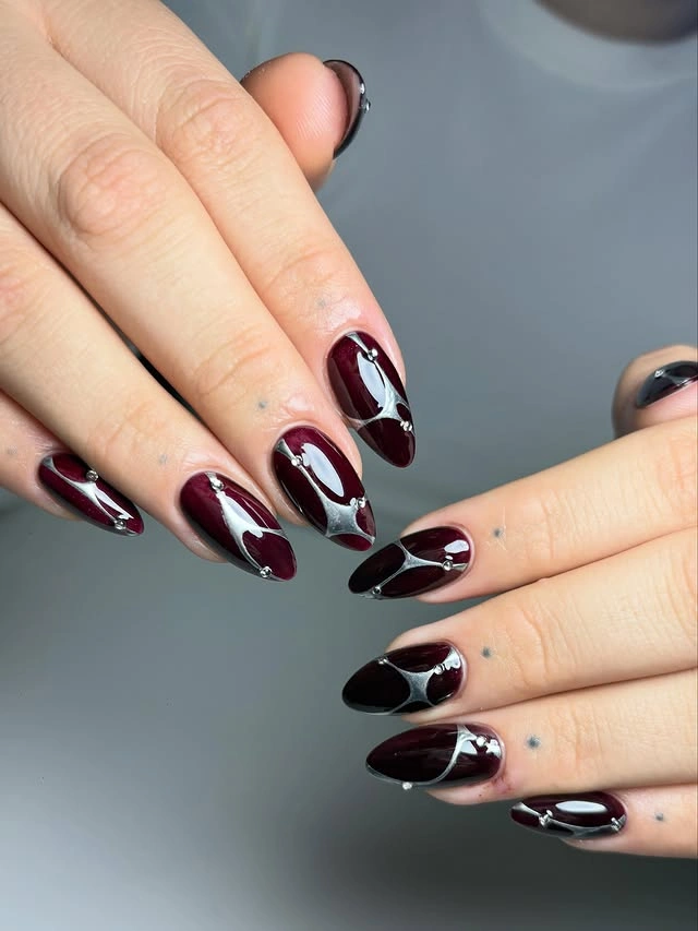 Long nude almond nails with large burgundy and black curved panels