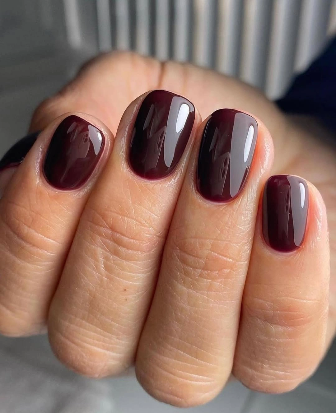 Short rounded square nails in glossy blackened burgundy