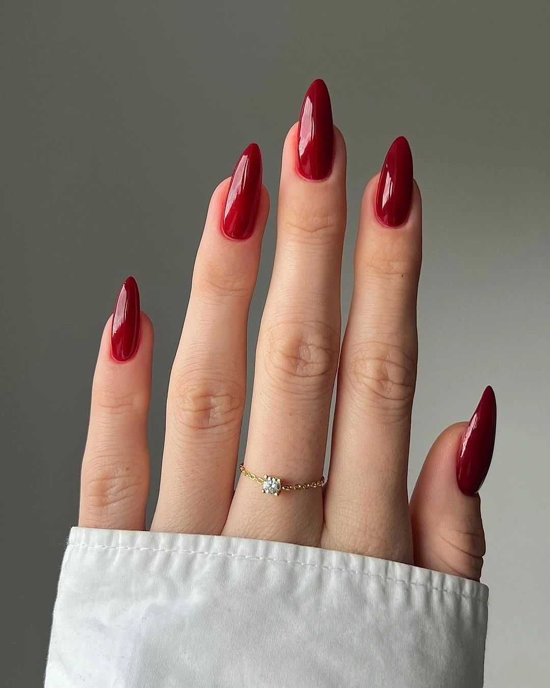 Long almond nails in a uniform deep red maroon color