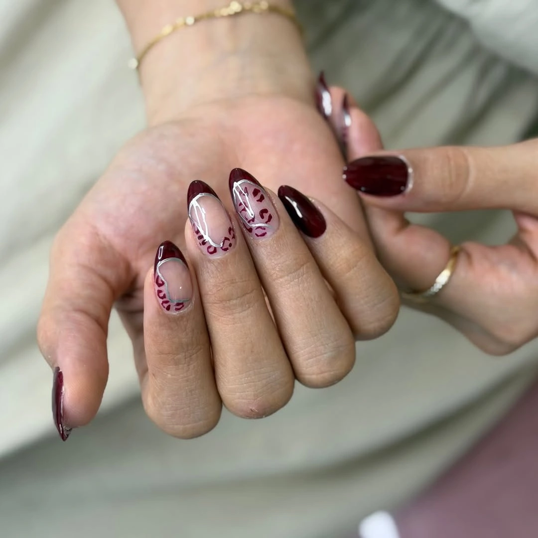 Almond nails with sheer nude base and curved burgundy edges