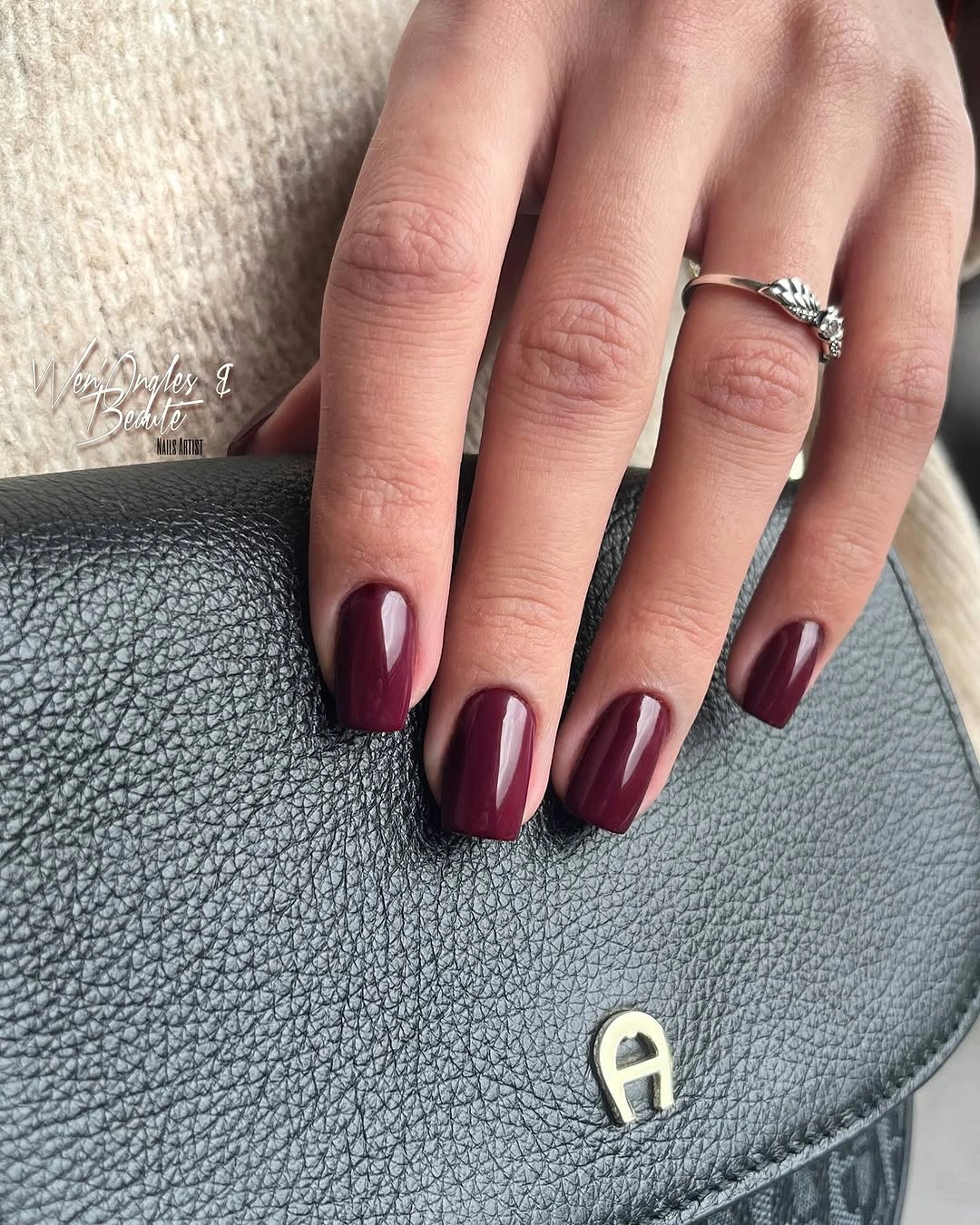 Short square nails in a muted glossy wine burgundy color