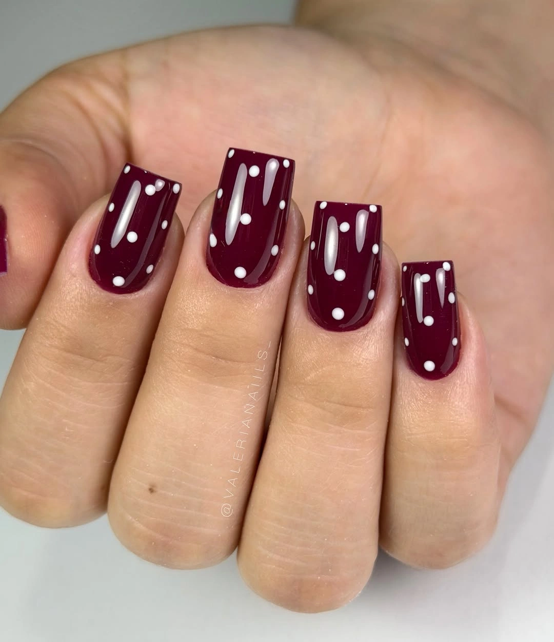 Short burgundy square nails with tiny white dots and lines