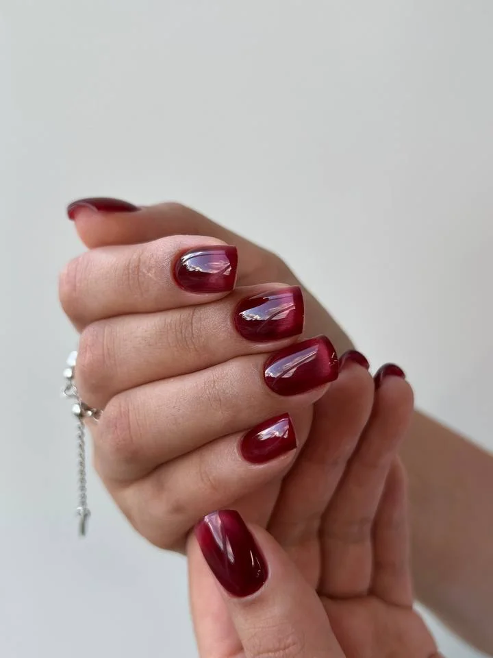 Short maroon square nails with pale pink and white curved accents