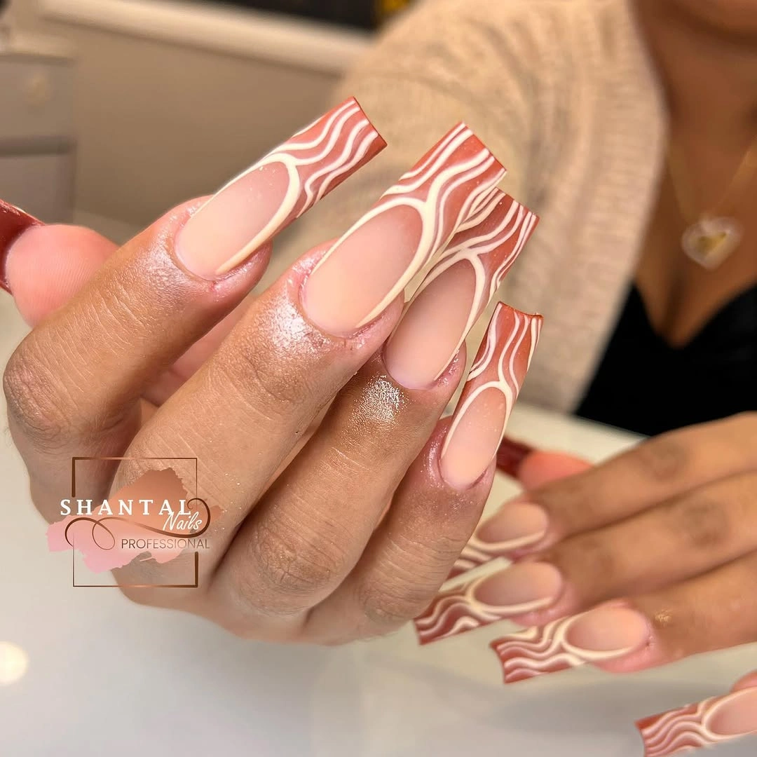 Long nude nails with cream and terracotta wavy contour accents
