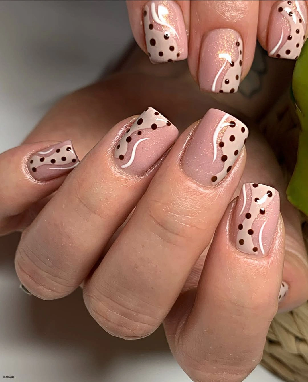 Short blush nude nails with black dots and loose white floral line details