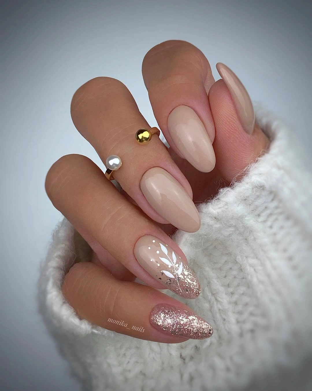 Nude almond nails with small silver details and one glitter accent nail