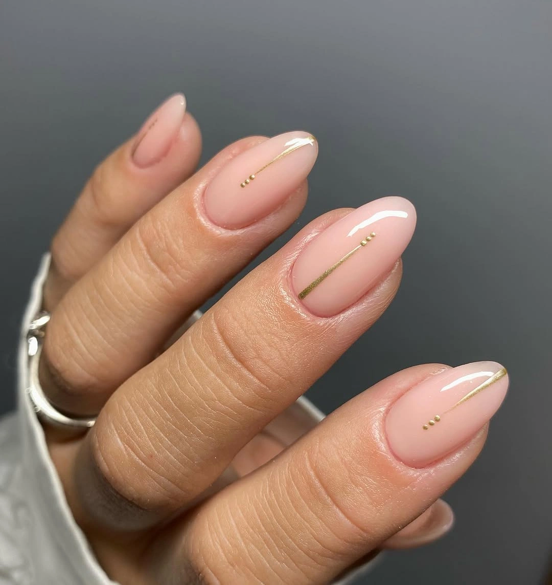 Pale nude almond nails with tiny minimalist botanical stem accents