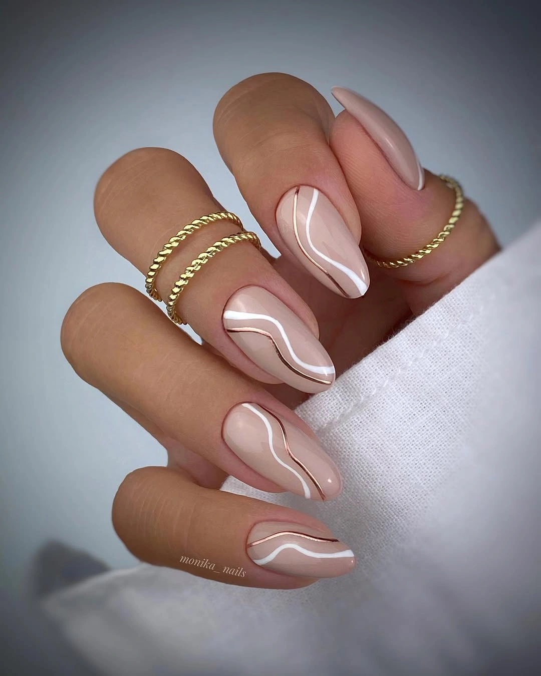 Long nude almond nails with flowing white organic double lines