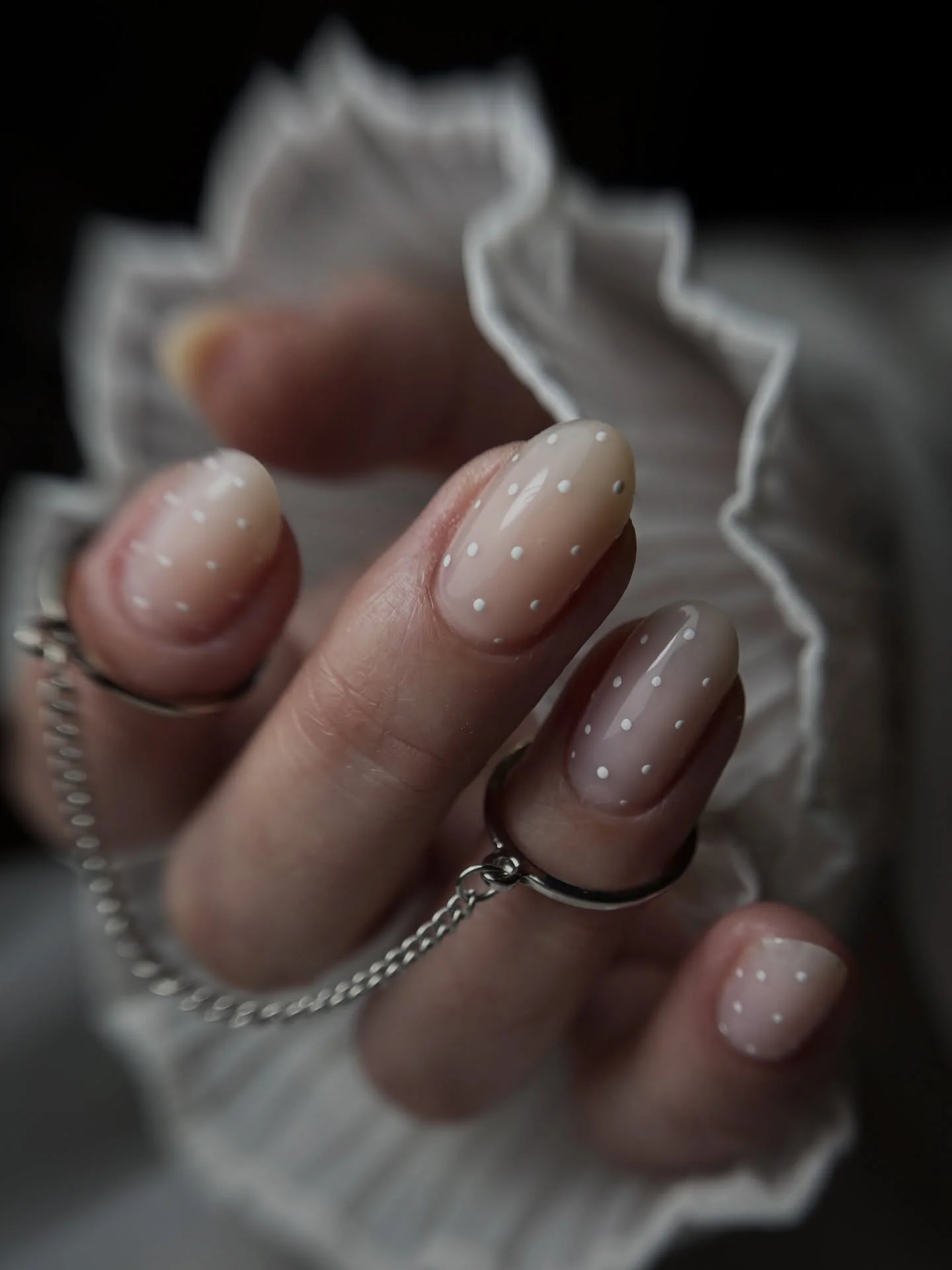 Sheer blush almond nails with minimal tiny white dot accents