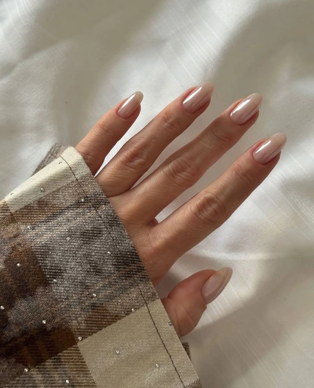 Medium oval nails in a quiet beige nude glossy finish