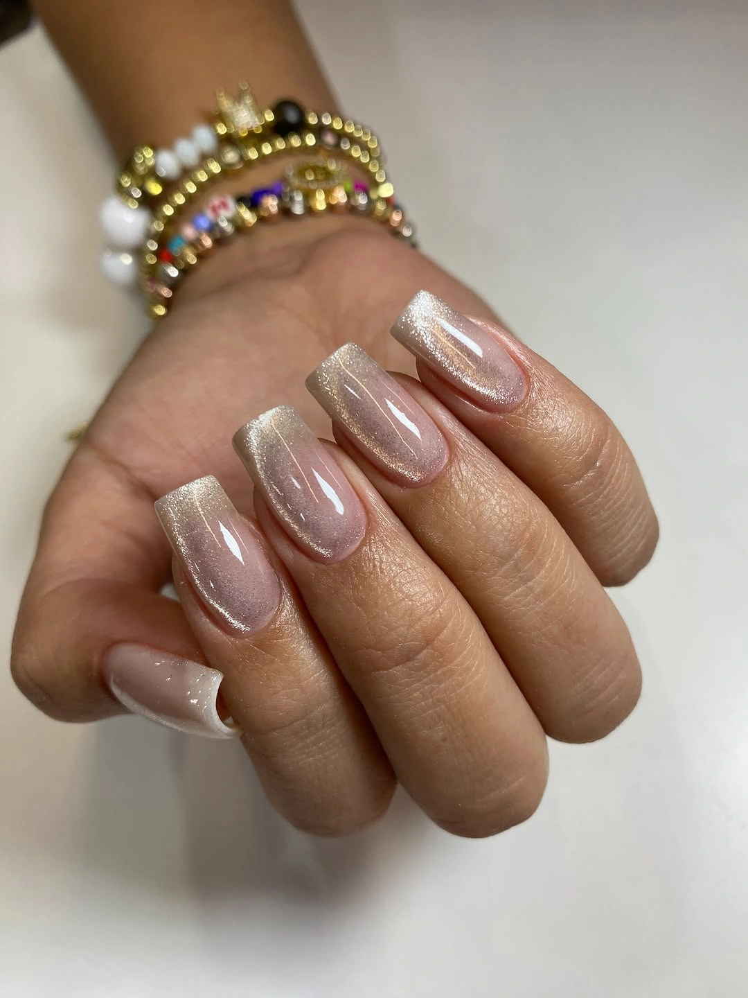 Taupe nude oval nails with a soft pearly reflective sheen