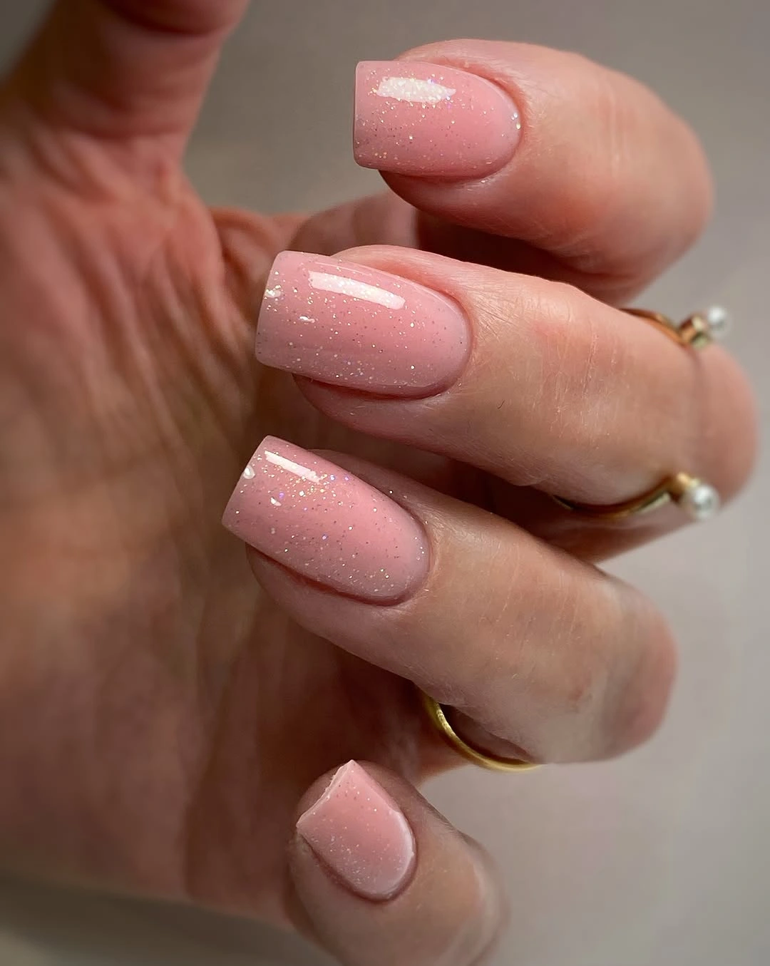 Short rose nude nails with delicate fine scattered sparkle