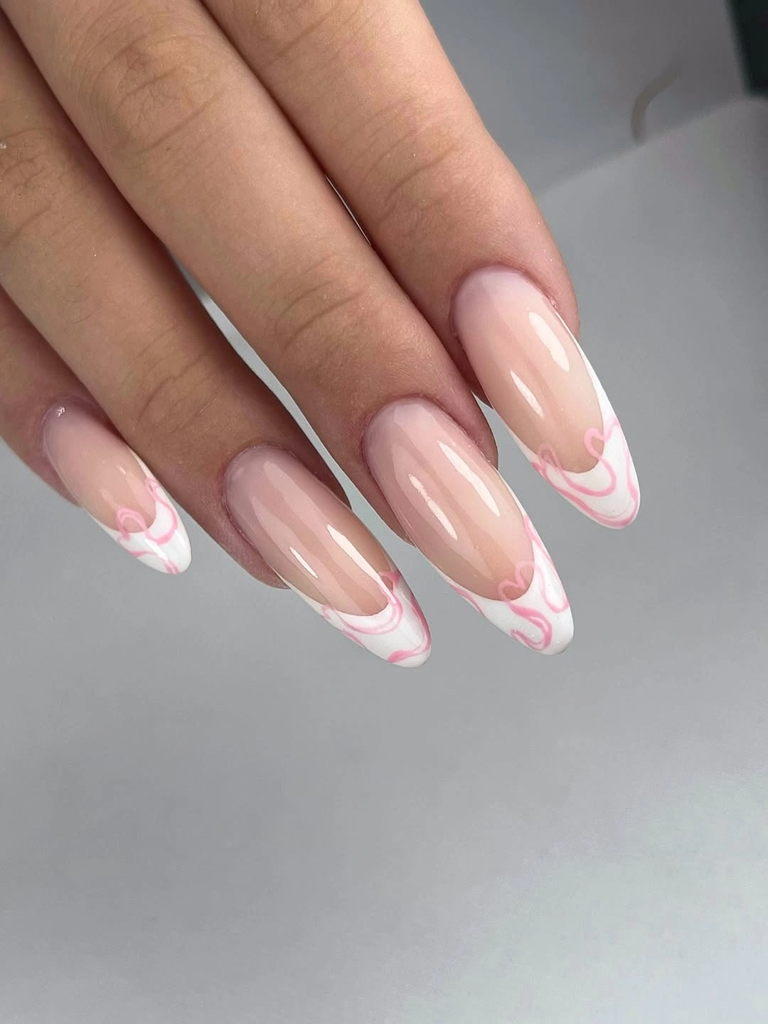 Nude almond nails with double white and pink wavy French tips