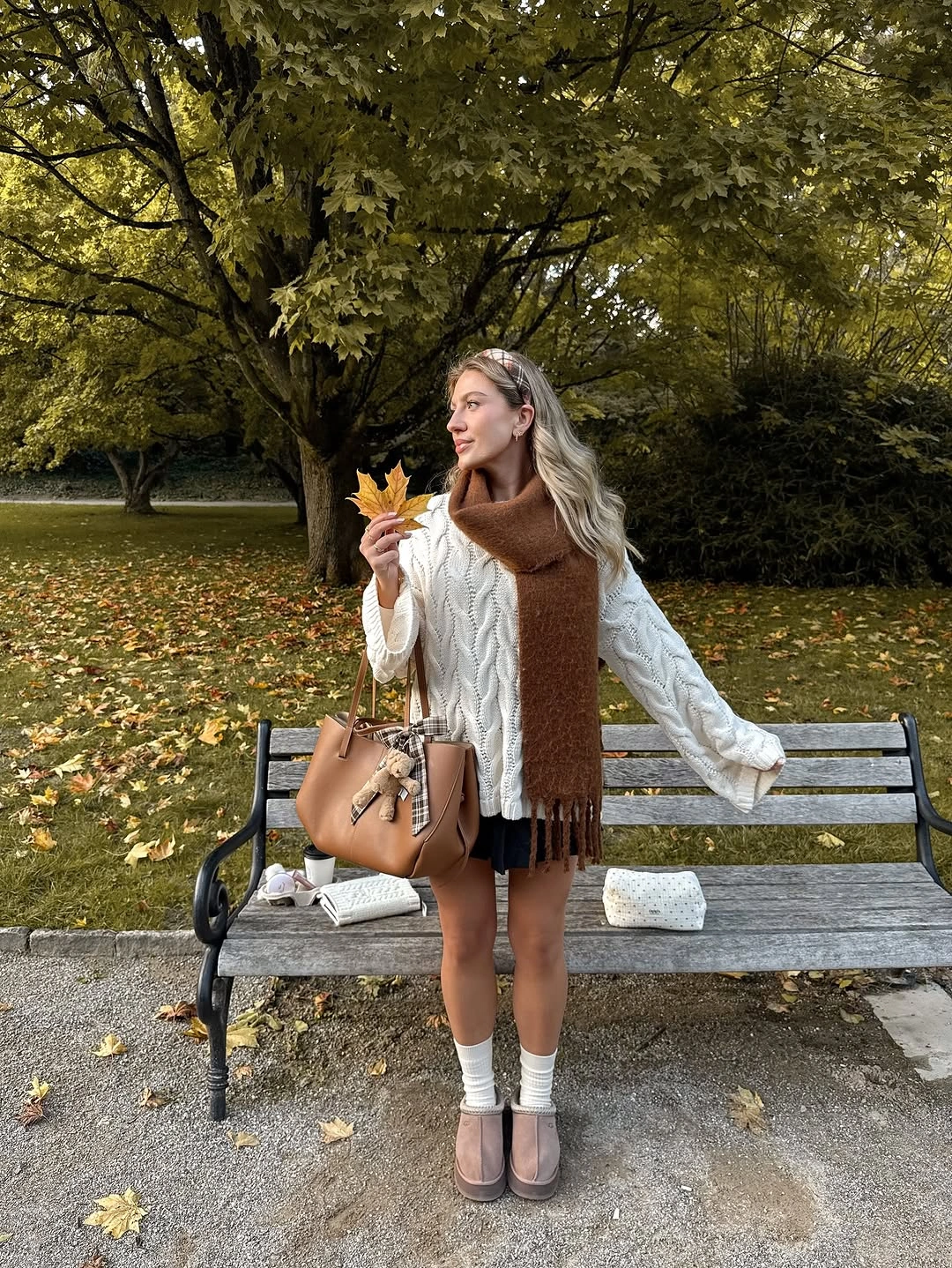 White blouse with large brown wrap, short black skirt, white socks, and dark strap shoes