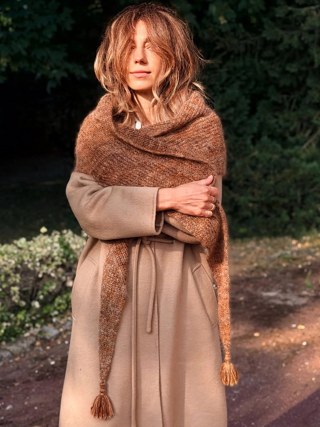 Large brown wrap layered over a long camel-toned outfit with ankle boots