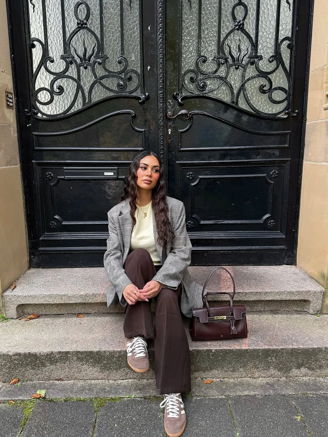Gray patterned blazer with brown trousers, silver sneakers, and structured handbag