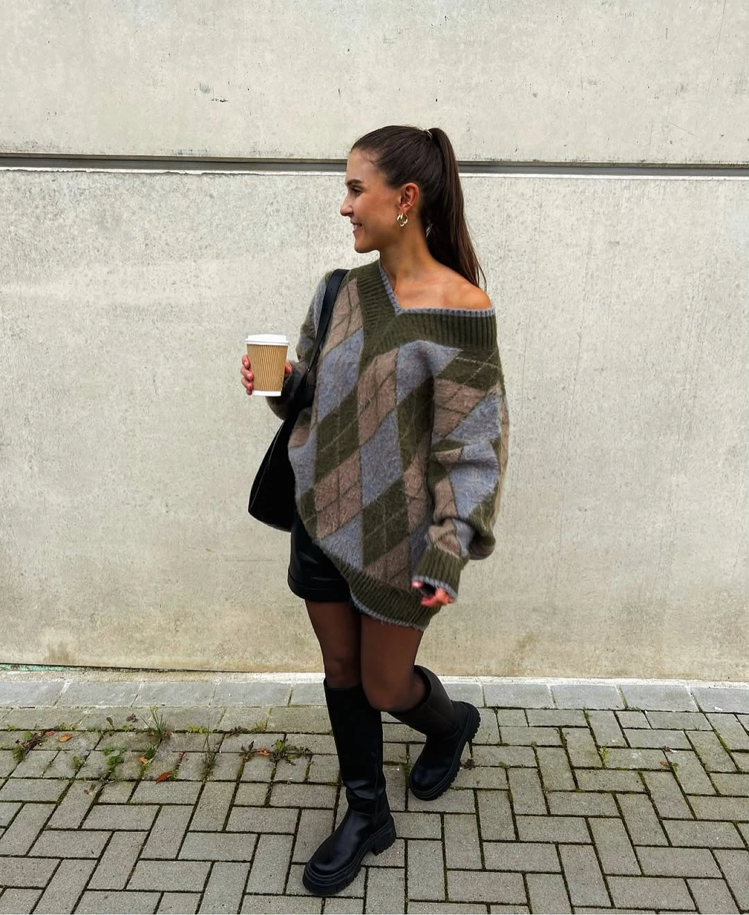 Oversized argyle knit over black mini skirt with tall black boots
