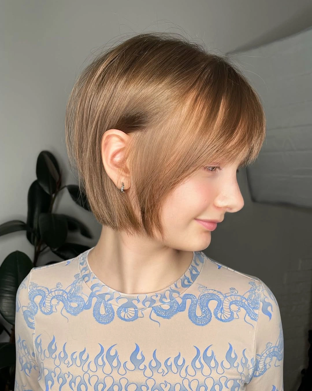 Warm brown jaw-length bob with side-swept fringe and rounded perimeter