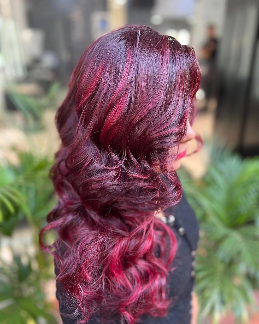 Long plum-red waves with brighter magenta ribbons and side-view curls