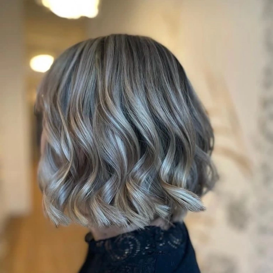 Short wavy bob with muted steel-blue lengths, dark root, and airy ends