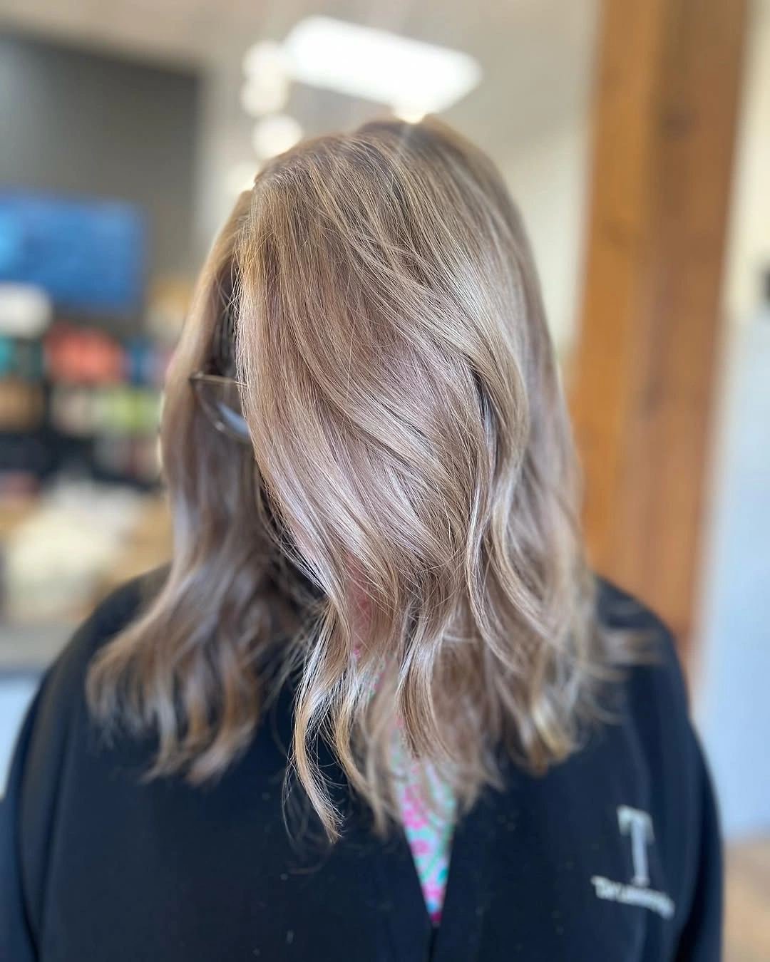 Medium cool taupe blonde waves with darker root and muted beige-gray dimension