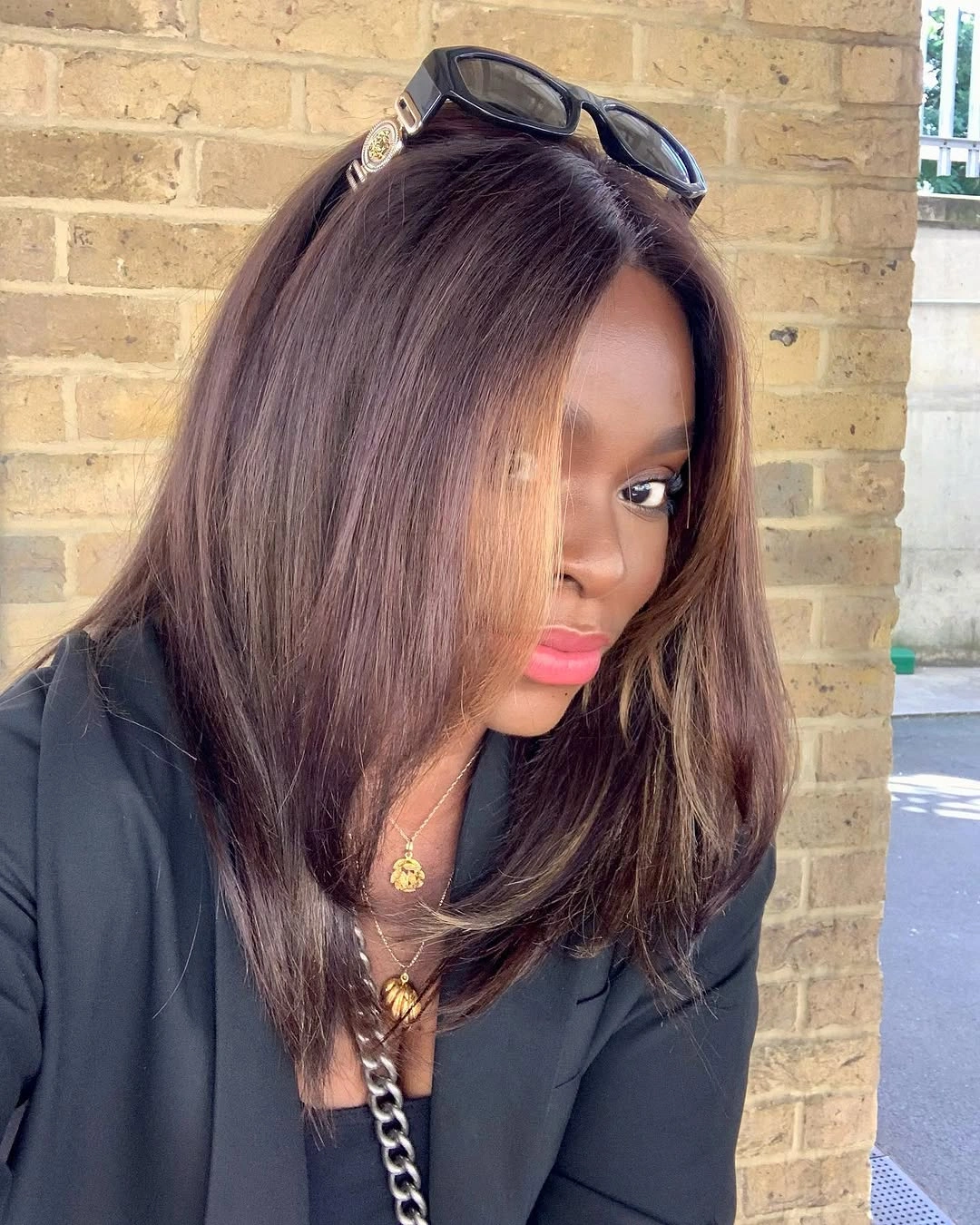Dark brown shoulder-length blowout with side part, soft layers, and warm-looking shine
