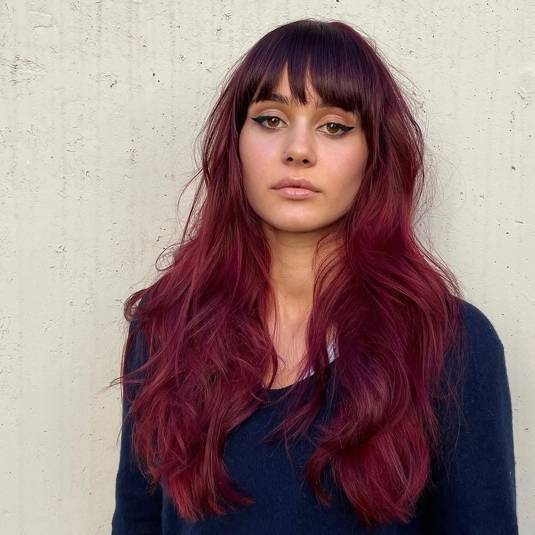 Long berry-red wavy hair with full straight fringe and darker crown