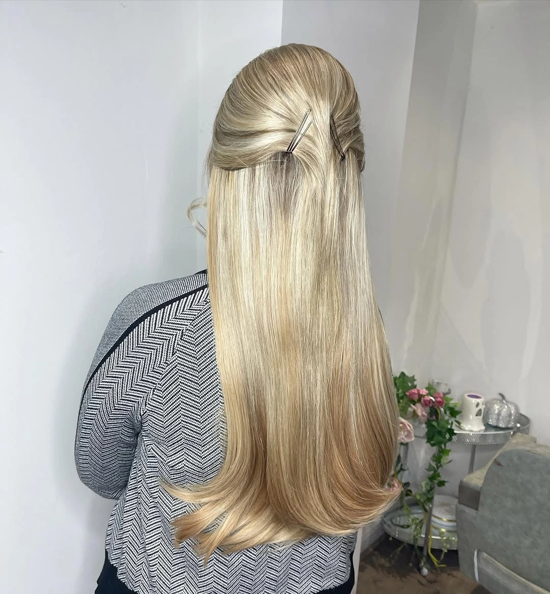 Long blended blonde hair with small twisted half-up detail and curled ends