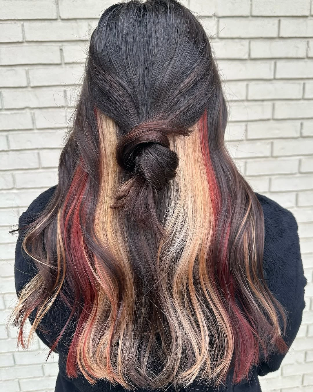 Long dark hair with low half-up knot, peach ribbons, and curled lower ends