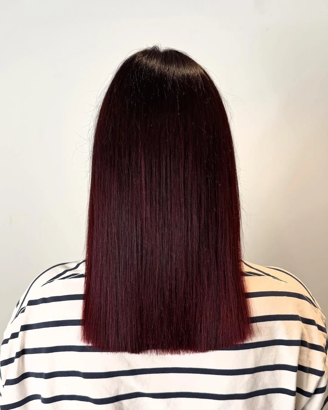Long straight deep burgundy hair with center part and even blunt perimeter
