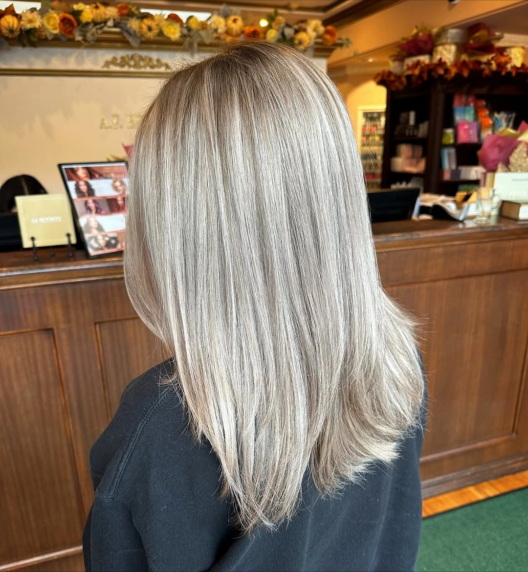 Bright silver-blonde shoulder-length lob with dark root depth and crisp blunt ends