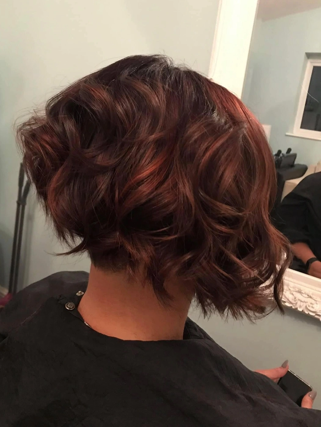 Short textured dark brown bob with piecey curved layers and cropped nape