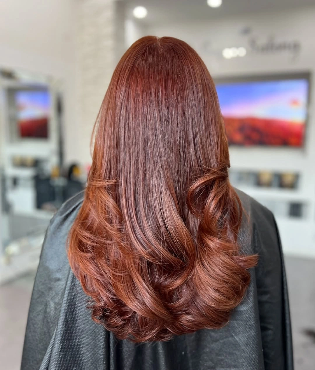 Medium red-brown haircut with smooth crown and curled lower layers at the ends