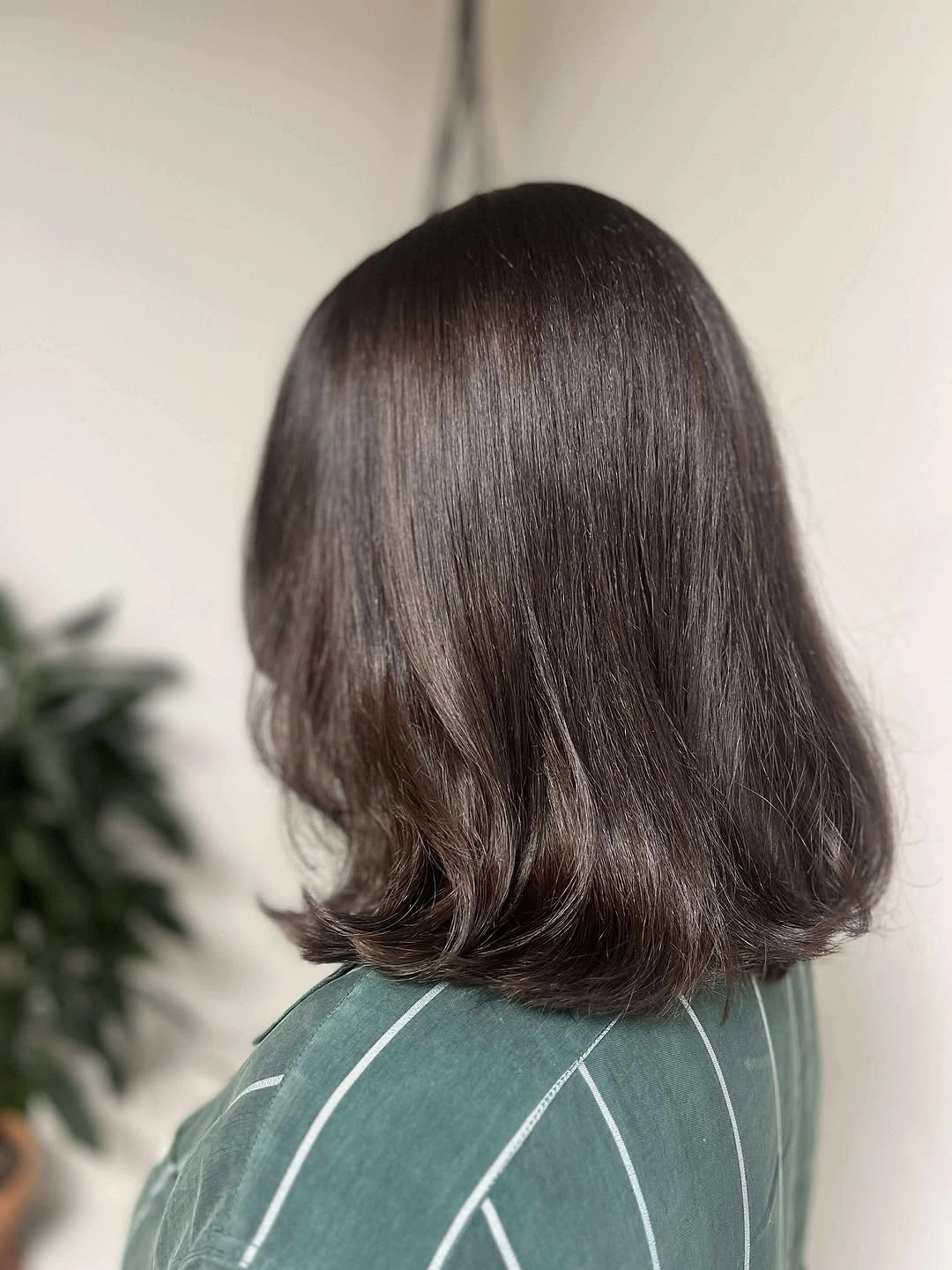 Dark brown shoulder-length haircut with smooth crown and softly flipped rounded ends