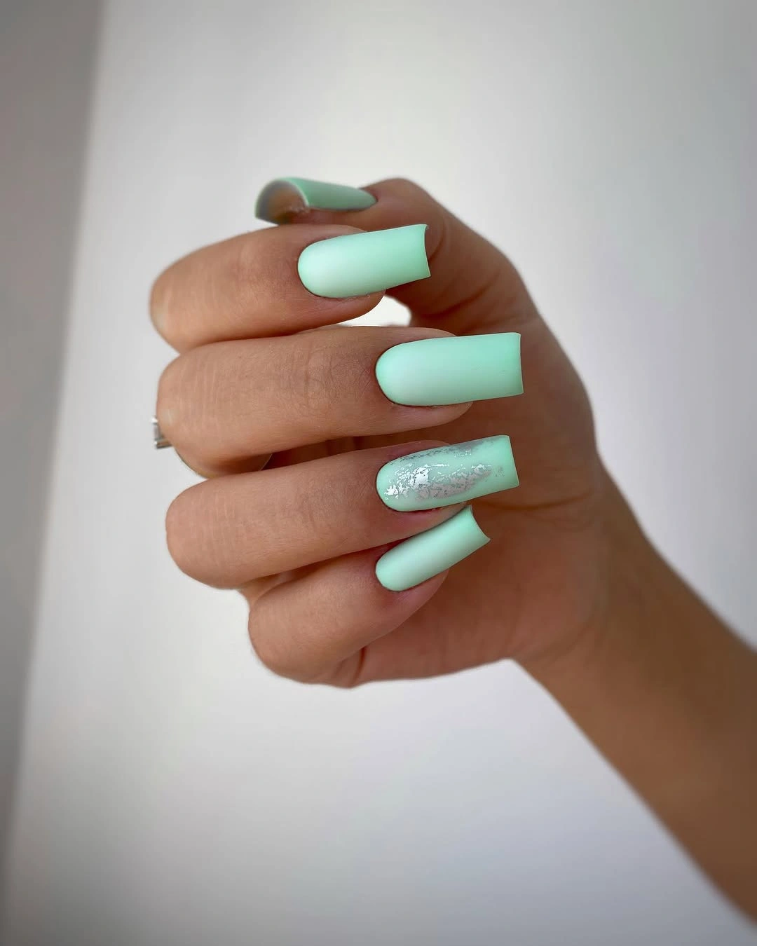 Long mint coffin nails with a single pale glitter accent nail