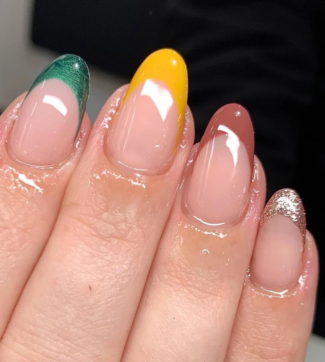 Nude almond nails with green yellow curved tips and silver accent