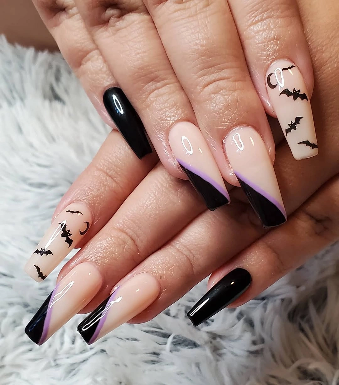 Long pointed nude nails with black lavender tips and tiny bat accents
