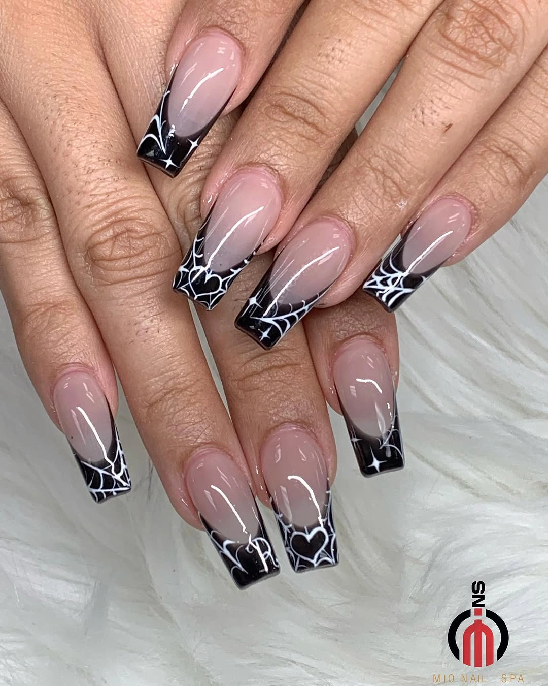 Nude square nails with black French tips and white spiderweb lines
