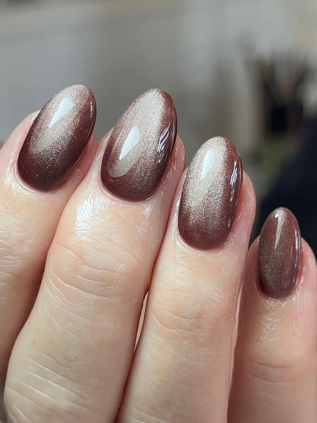 Taupe brown almond nails with a soft pearly reflective shimmer