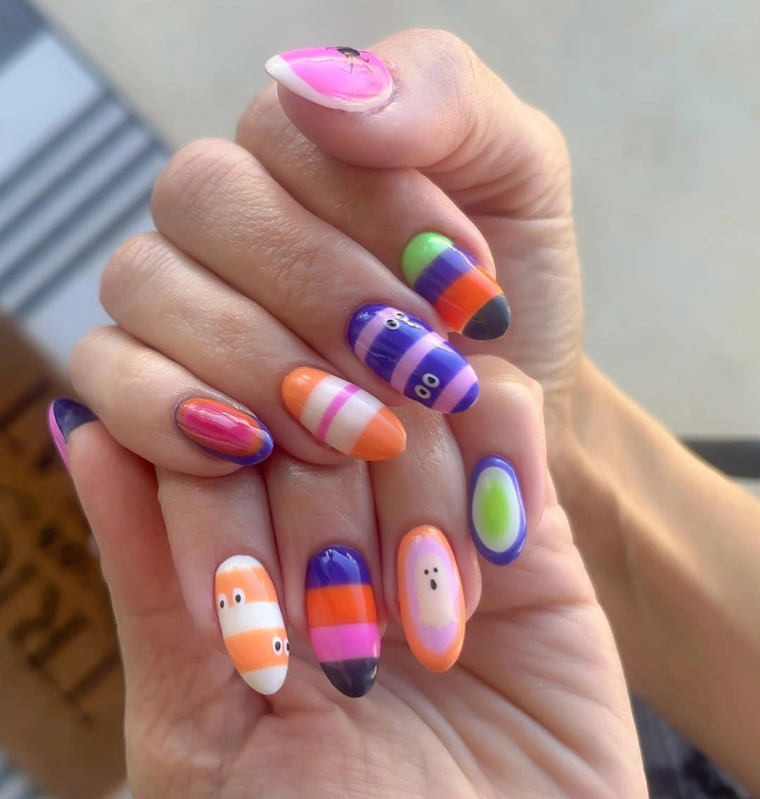 Long almond nails with rainbow bands tiny ghosts and bright circles