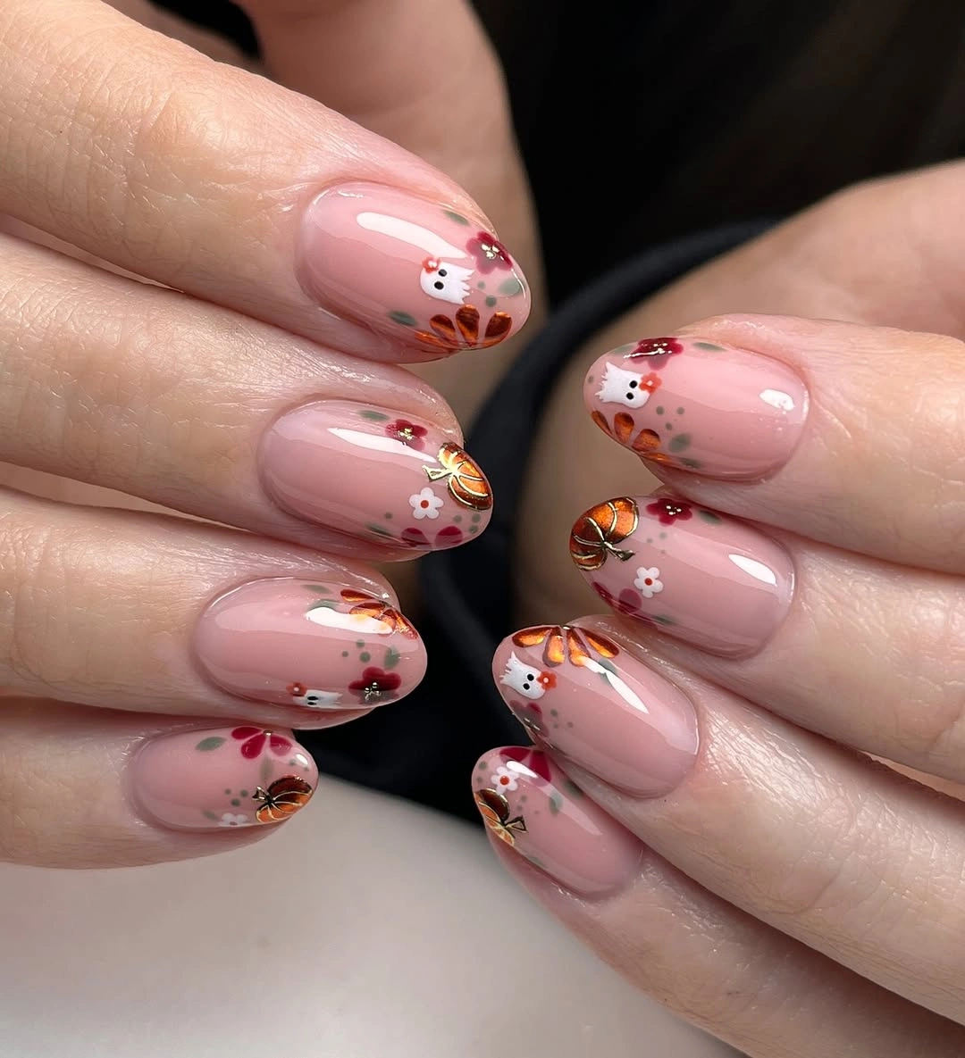 Pale pink almond nails with tiny red berries orange motifs and white accents