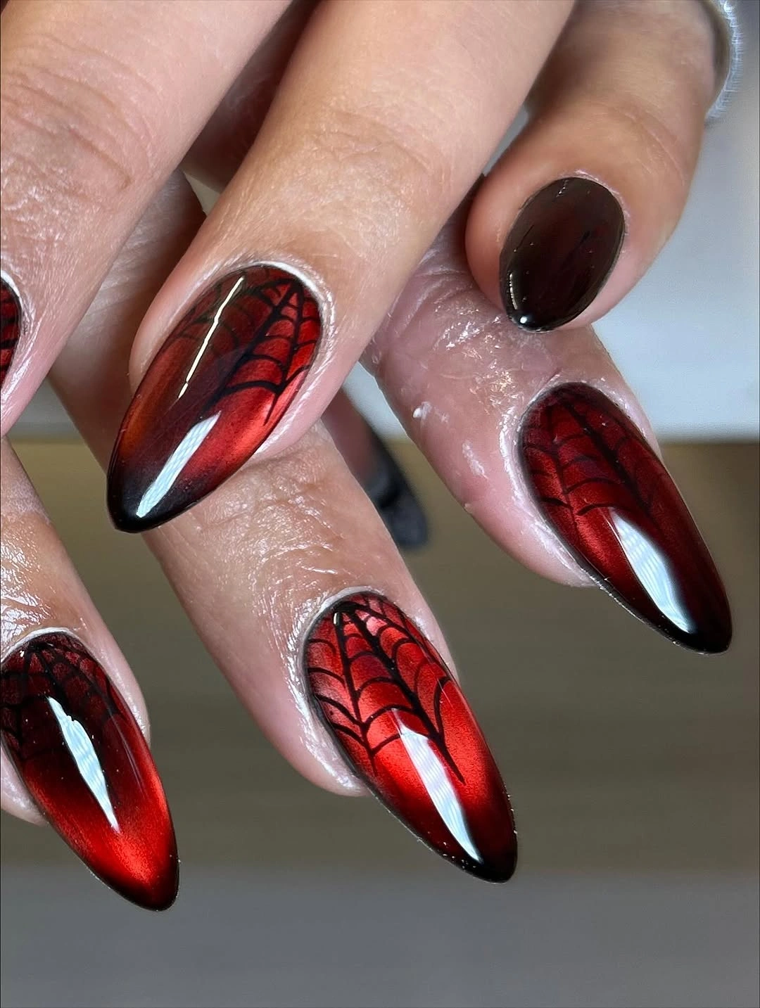 Long pointed red reflective nails with black spiderweb lines