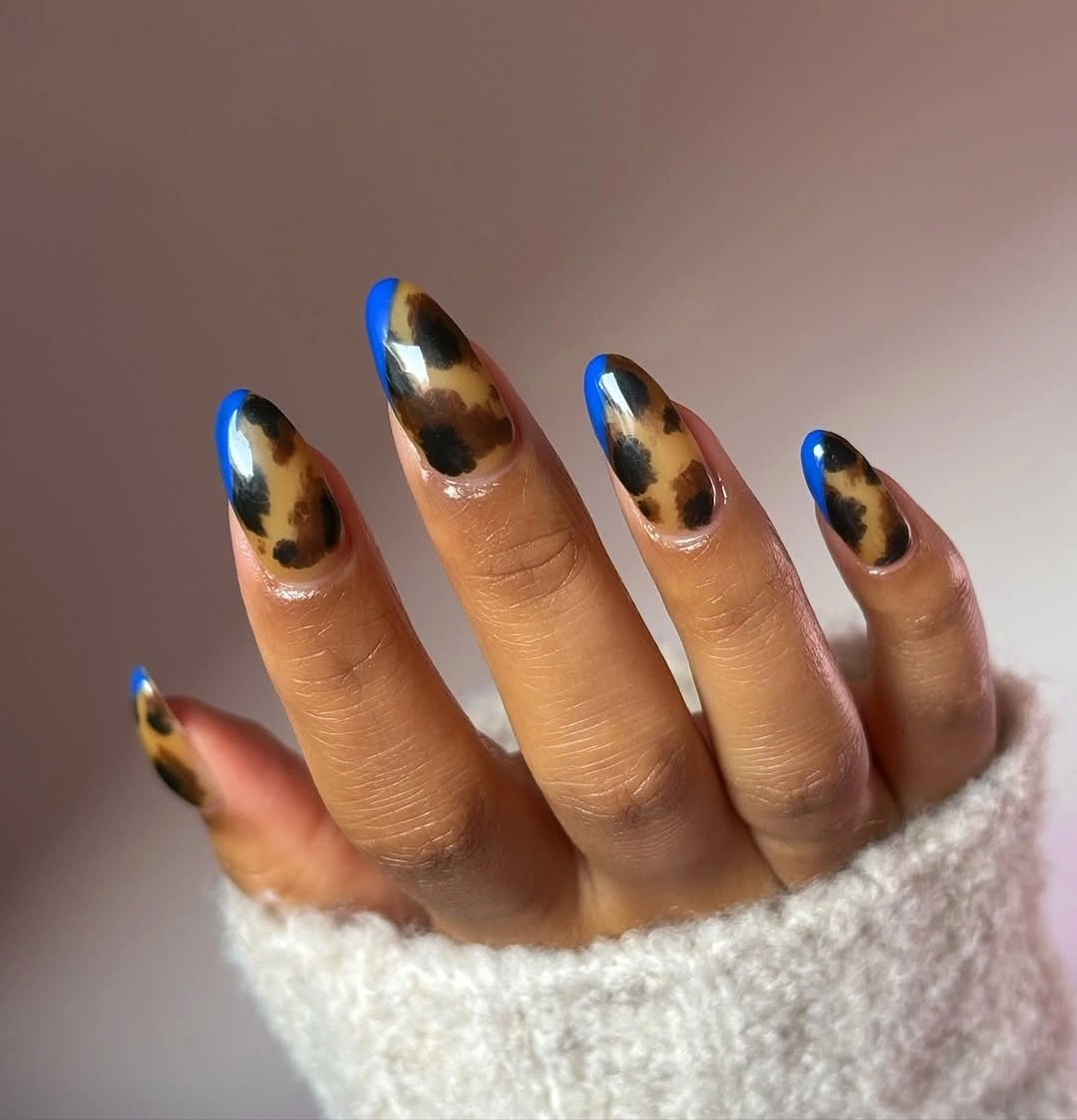 Almond nails with brown tortoiseshell centers and bright blue edges