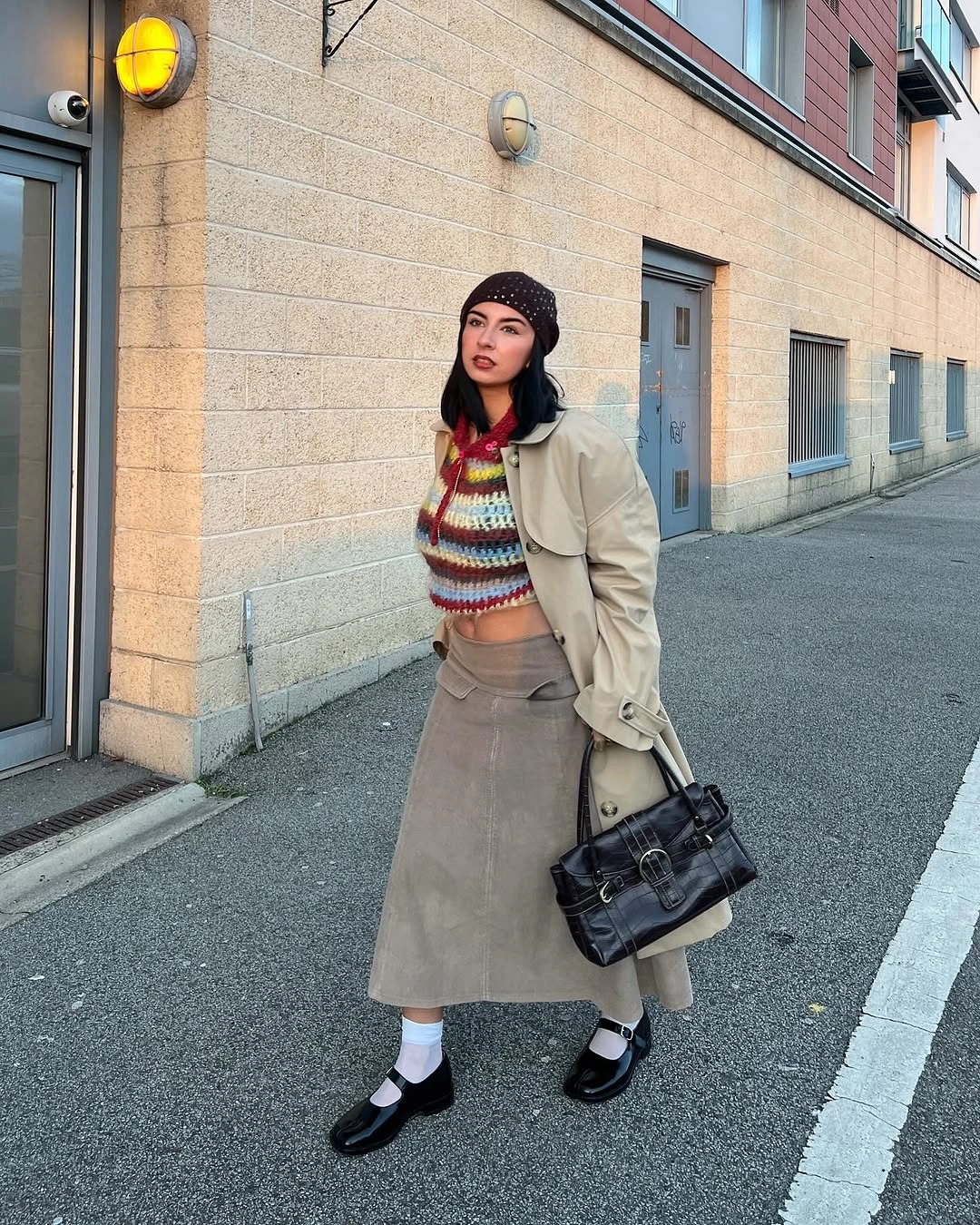 Light trench coat with colorful striped sweater and taupe midi skirt